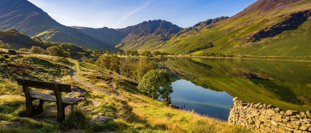 An Image of a park bench overlooking a lake in the Lake District National Park